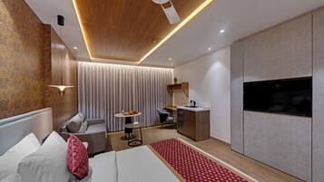Una habitación de hotel moderna con cama, escritorio, silla, televisor y ventilador de techo.