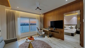Una habitación de hotel moderna con una cama grande, un escritorio, un televisor y vistas a la ciudad.
