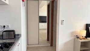 Moderni keittiö, jossa on leivänpaahdin, liesi ja liukuovi, joka johtaa olohuoneeseen.