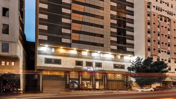 A modern high-rise hotel with a prominent vertical design, featuring a mix of glass and solid panels. - Razana Al Hafayyer (Makkah)