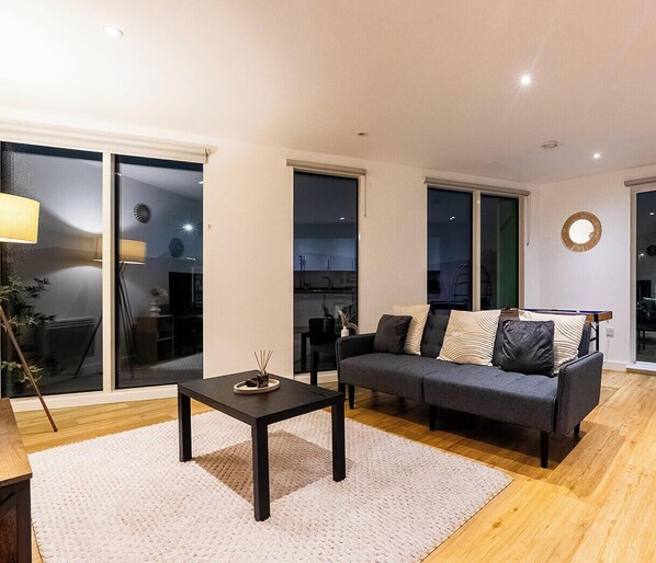 Un salon moderne avec un canapé, une table basse et une grande fenêtre.
