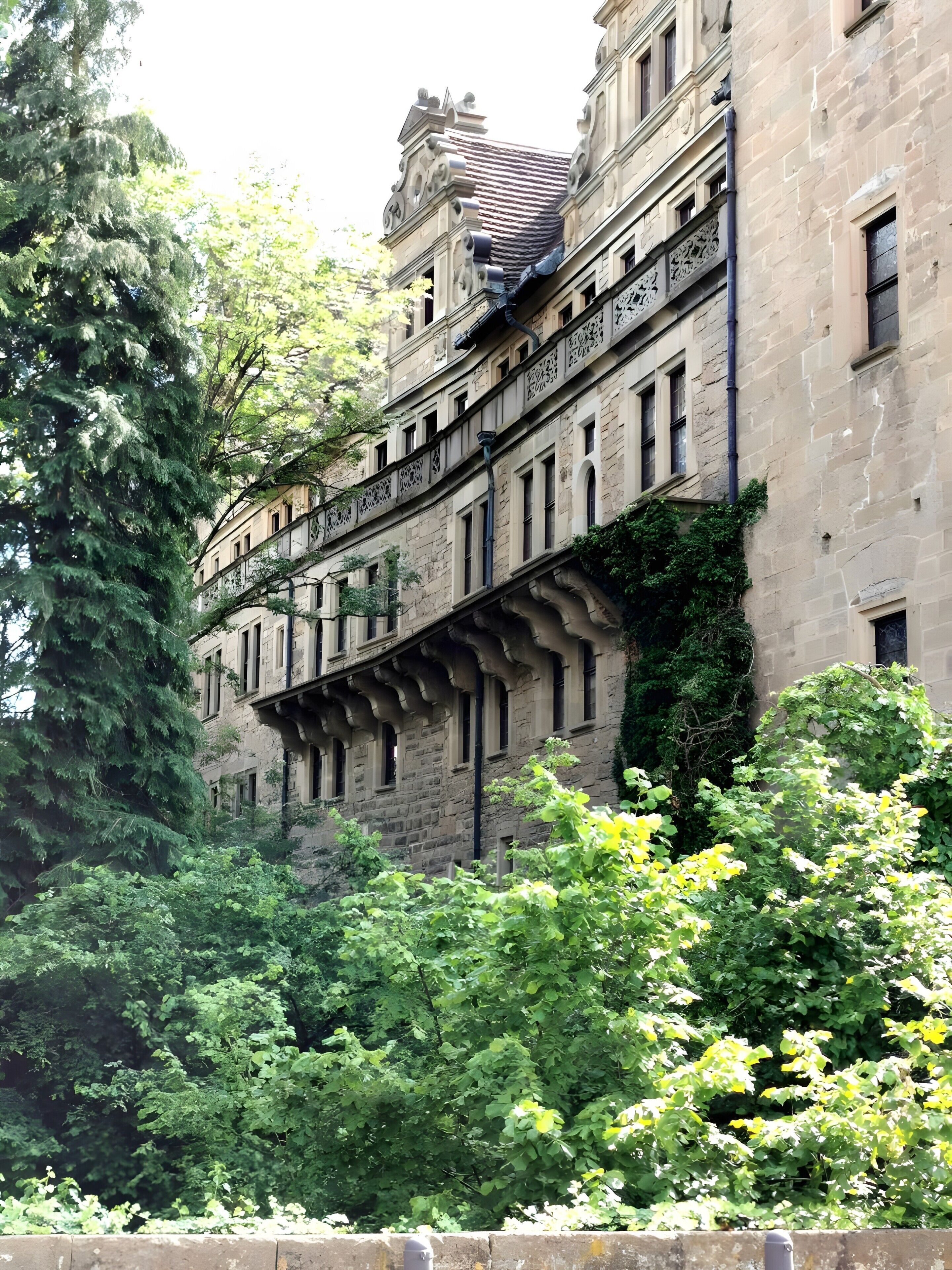 A historic building with ornate architectural details, including a balcony with intricate railings and a stone facade.