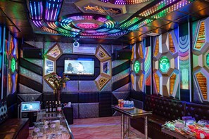 A modern bar area with neon lights, a TV screen, and a variety of seating options. - Muong Hoa River View Homestay (Ta Van)