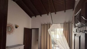 A bedroom with a bed, a wardrobe, a mirror, and a door. - Oceanfront apartment 18 Lagun Blou Resort (Lagun)