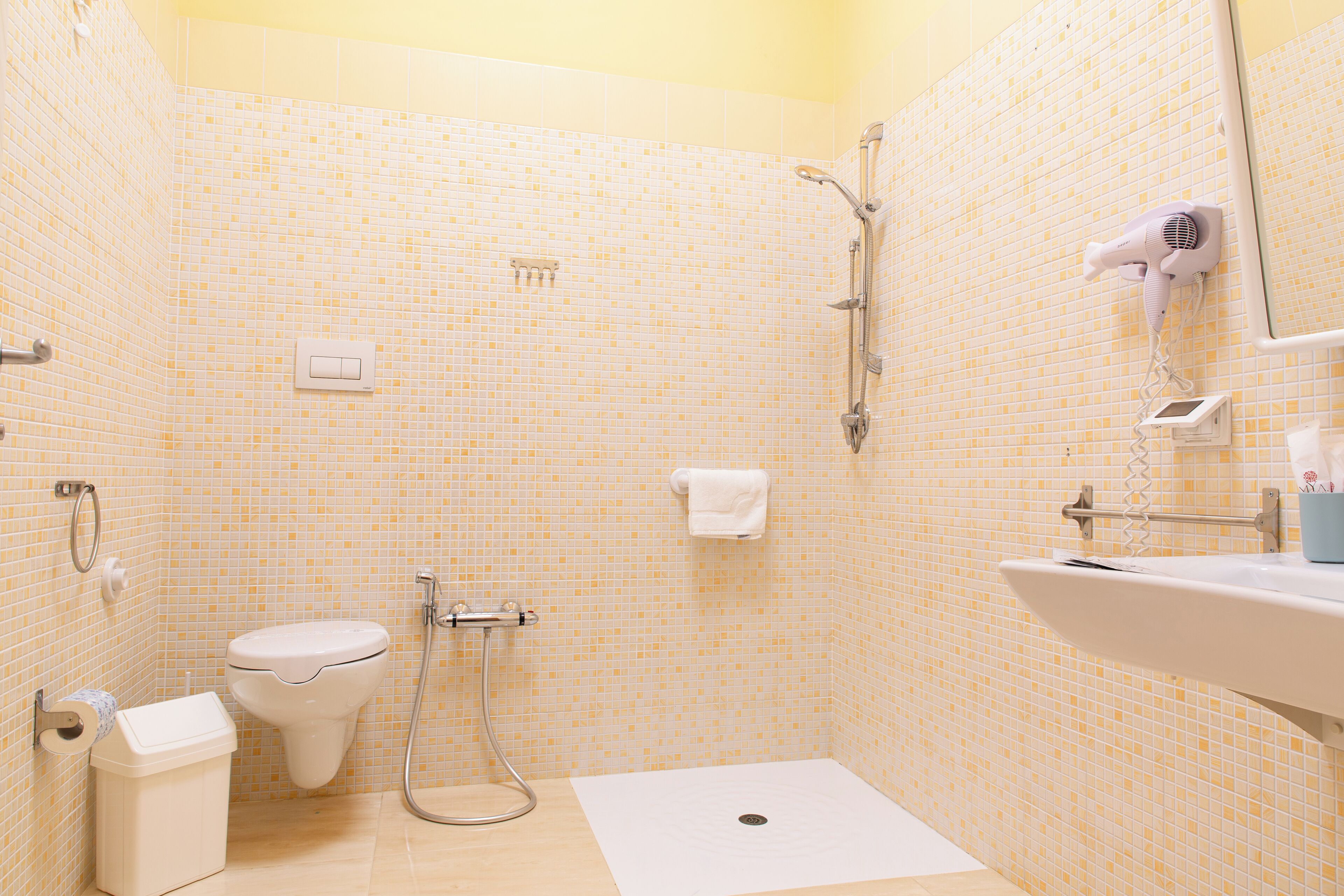 A small bathroom with a toilet, sink, and shower.