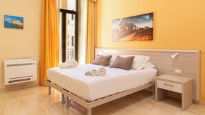 A neatly made bed with pillows, a bedside table, and a wall-mounted picture. - Syraka Hotel LR Collection (Syracuse)