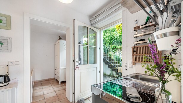 A kitchen with a built-in stove, a sink, and a window overlooking a garden. - Apartment 'Romantica' with Lake View, Private Terrace and Wi-Fi (Sipplingen)