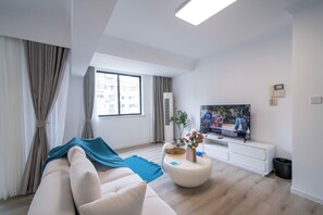 Căn hộ Superior, 2 phòng ngủ, quang cảnh thành phố | Phòng khách | Smart TV 55-inch có truyền hình cáp