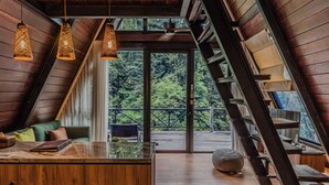 A modern interior with wooden beams, a central island, and a view of the outdoors. - Lawangkala Resort Ubud (Ubud)