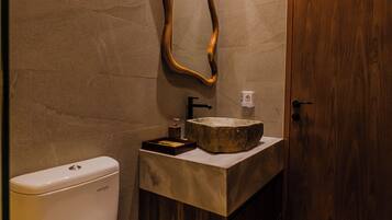 A modern bathroom with a toilet, sink, and wooden door.