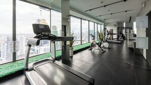 A modern gym with a treadmill, stationary bikes, and exercise equipment. - M Residence-Cozy Stay by Soben Homes (Phnom Penh)