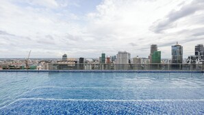 A rooftop pool with a city skyline view. - M Residence-Cozy Stay by Soben Homes (Phnom Penh)