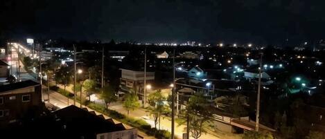 Vista nocturna de un paisaje urbano con edificios e iluminadas calles.