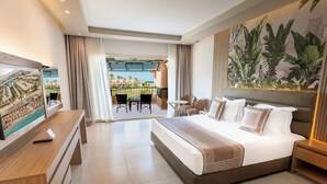 A hotel room with a bed, a TV, a desk, a balcony with a view, and a large plant. - Ali Baba Palace Resort - Families and Couples Only  (Hurghada)