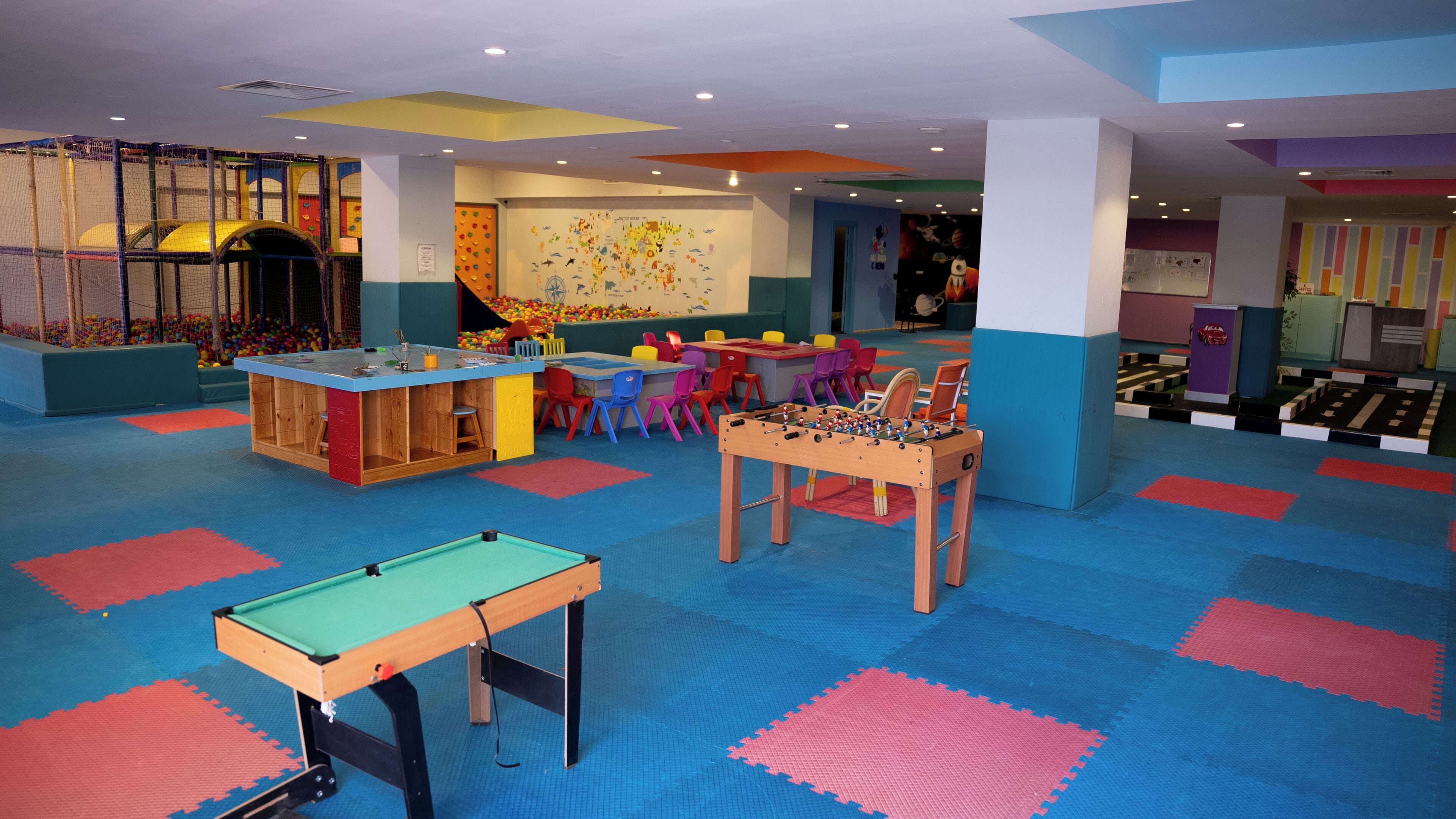A children's play area with a pool table, foosball table, and a ball pit.
