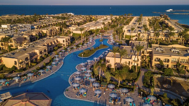 A resort with a central swimming pool, multiple lounge areas, and a view of the sea. - Ali Baba Palace Resort - Families and Couples Only  (Hurghada)