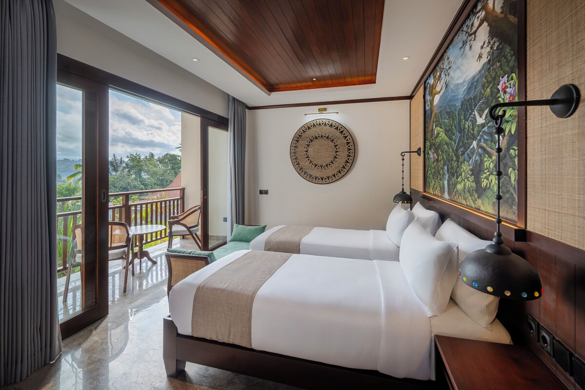 A hotel room with two beds, a balcony with chairs, a large wall painting, and a ceiling with wooden beams.