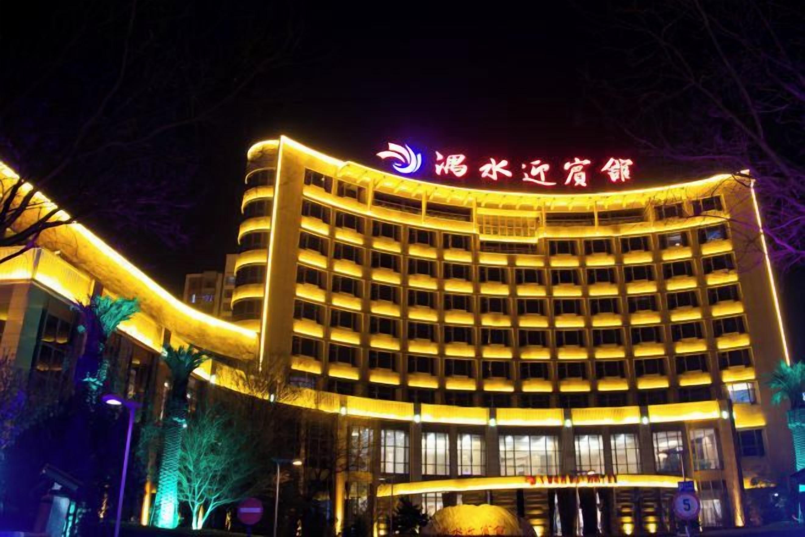 A multi-story hotel with a prominent curved facade and illuminated signage.
