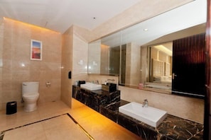A modern bathroom with a large mirror, two sinks, a toilet, and a shower area. - Yushui Hotel (Shahe)