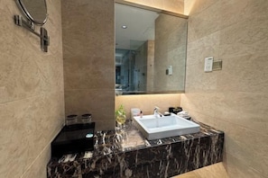 A modern bathroom with a marble countertop, a large mirror, and a built-in sink. - Yushui Hotel (Shahe)