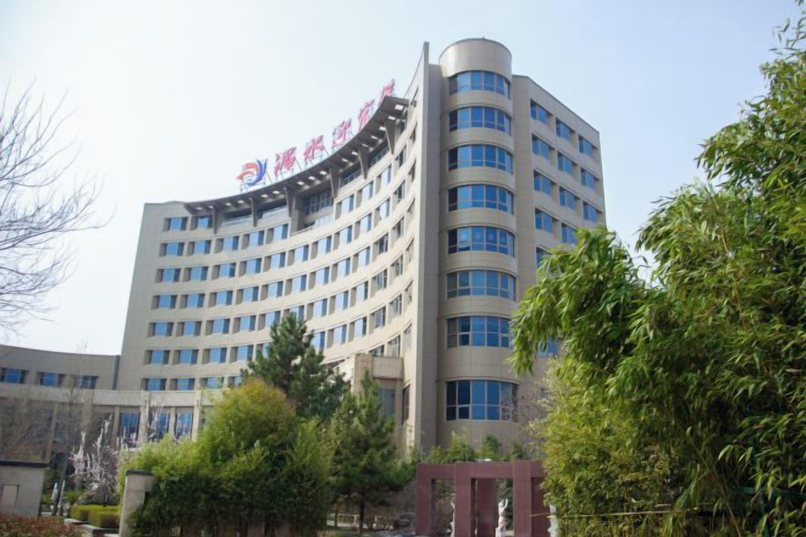 A multi-story building with a curved facade and a prominent entrance.