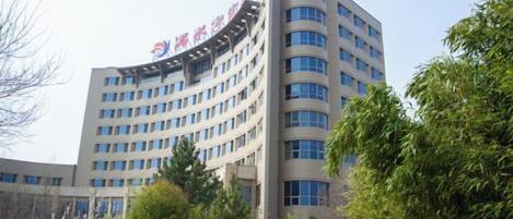 A multi-story building with a curved facade and a prominent entrance.