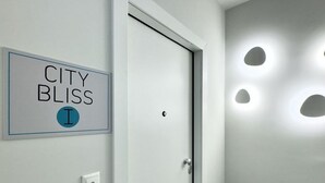 A hallway with a door, a sign reading "CITY BLISS I", and recessed lighting on the wall. - City Bliss I Trikala Town (Trikala)