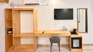 A room with a wooden desk, a chair, a TV, a shelf, and a small cabinet. - AIMI Beach, Gulhi Island, Maldives (Gulhi)