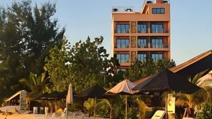 A hotel with a modern design, featuring multiple floors and large windows. - AIMI Beach, Gulhi Island, Maldives (Gulhi)