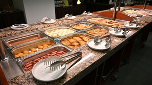 Un buffet proposant une variété de plats et d’ustensiles de service.