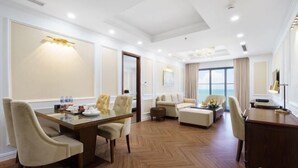 A spacious conference room with a wooden floor, a large table with chairs, and a sofa. - Victory Hotel Vung Tau - New Wing (Vung Tau)