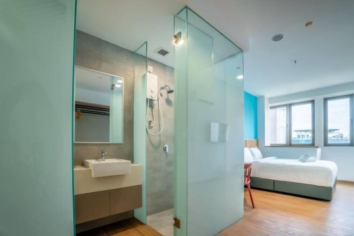 A modern bathroom with a glass partition, a sink, and a shower.