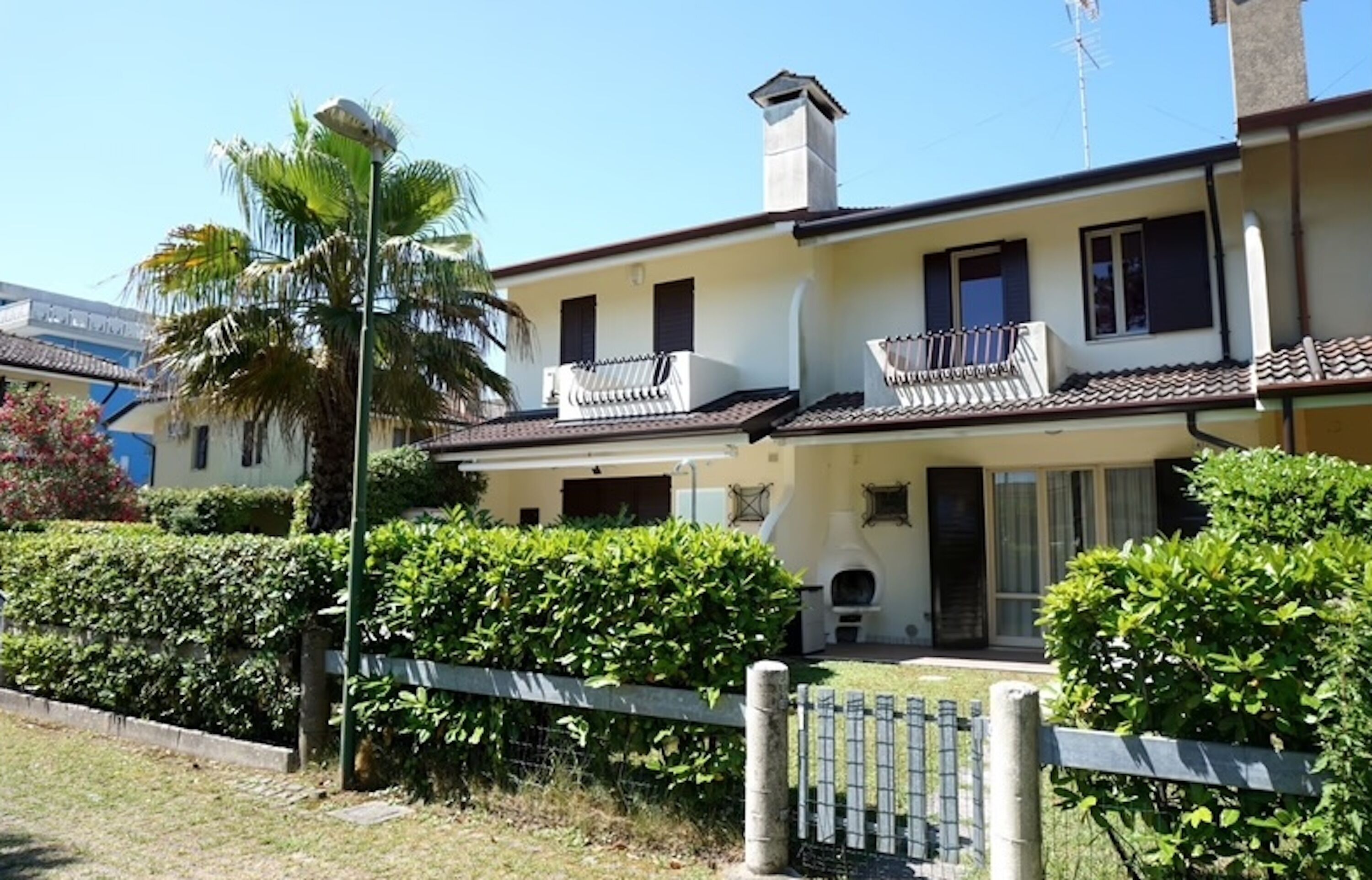 A two-story building with a balcony, a chimney, and a small front porch.
