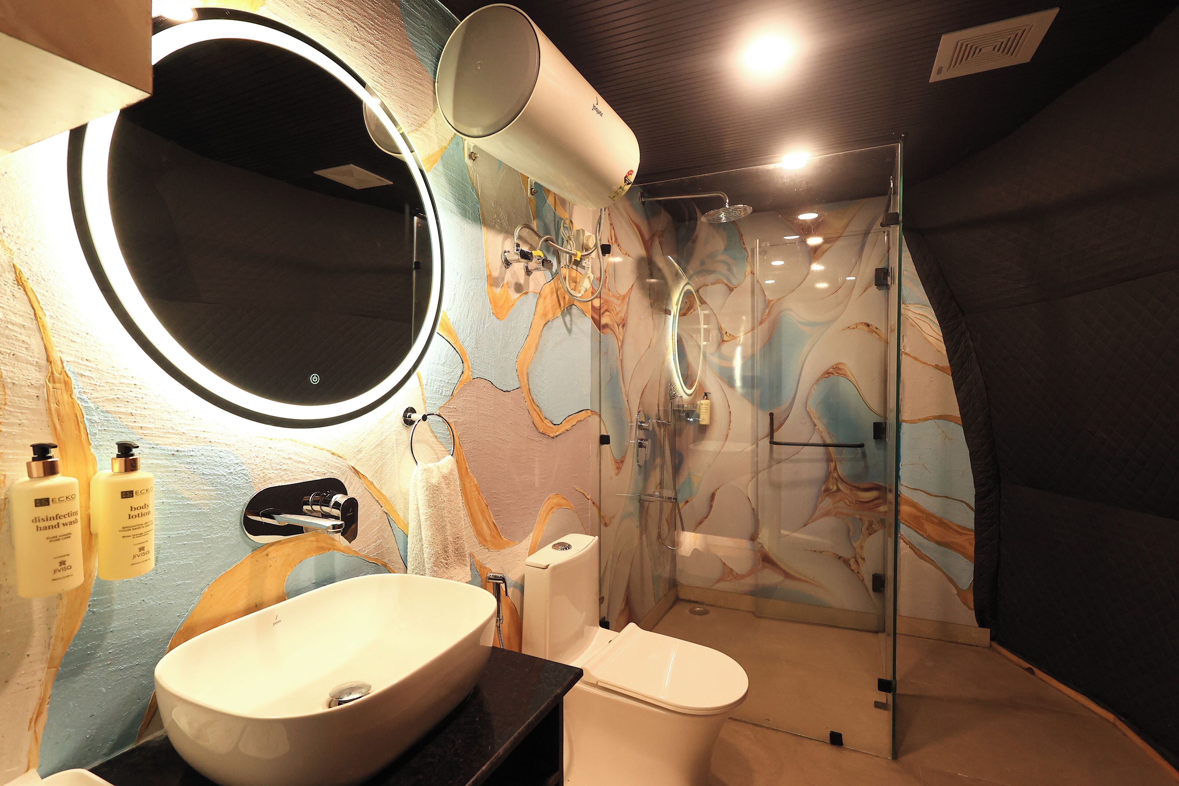 A modern bathroom with a large sink, toilet, and glass-enclosed shower.