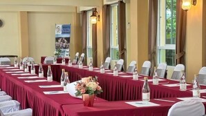 A conference room with a long table, chairs, water bottles, and a flower vase. - Wellness World Chiva Khao Yai (Pak Chong)
