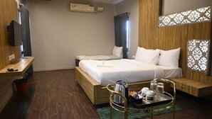 A hotel room with a bed, bedside table, and a small seating area with a tray table. - ZIPP Lite Frazer Town  (Bengaluru)