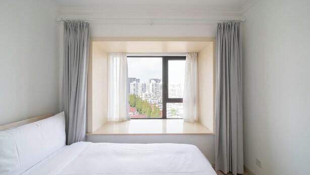 A bedroom with a large window, a bed, and curtains. - Tyms 2BR APT Xujiahui Dacheng Residence (Shanghai)
