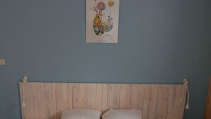 A bed with white linens, a wooden headboard, and a wall-mounted light fixture. - Apartment resort ÔMyrtilles (Besse-et-Saint-Anastaise)