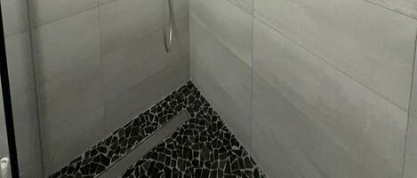 Een douche met een handdouche en een wandmengkraan.