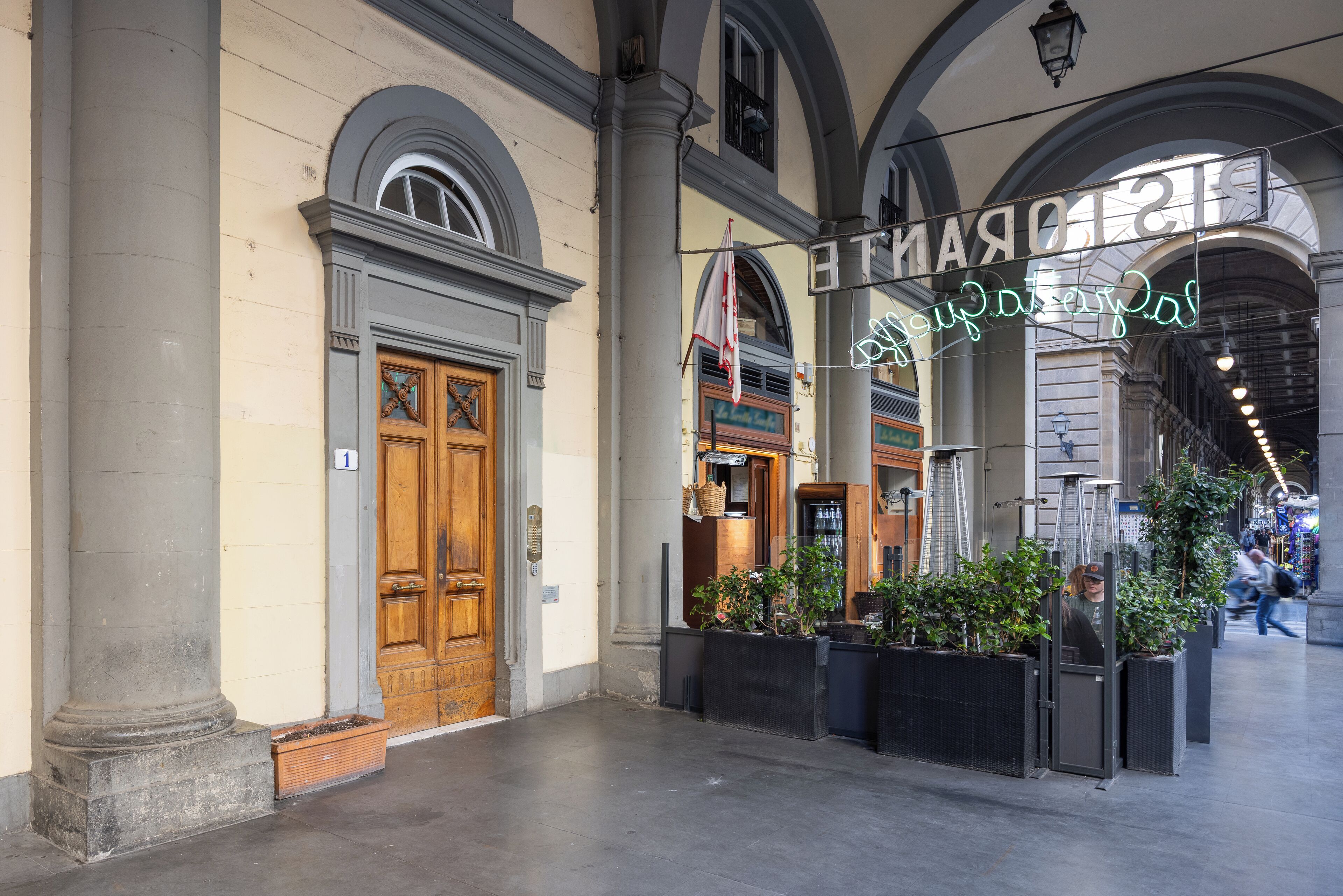 Un bâtiment historique doté d’une grande porte en bois, de colonnes et d’une enseigne indiquant « Hôtel ».