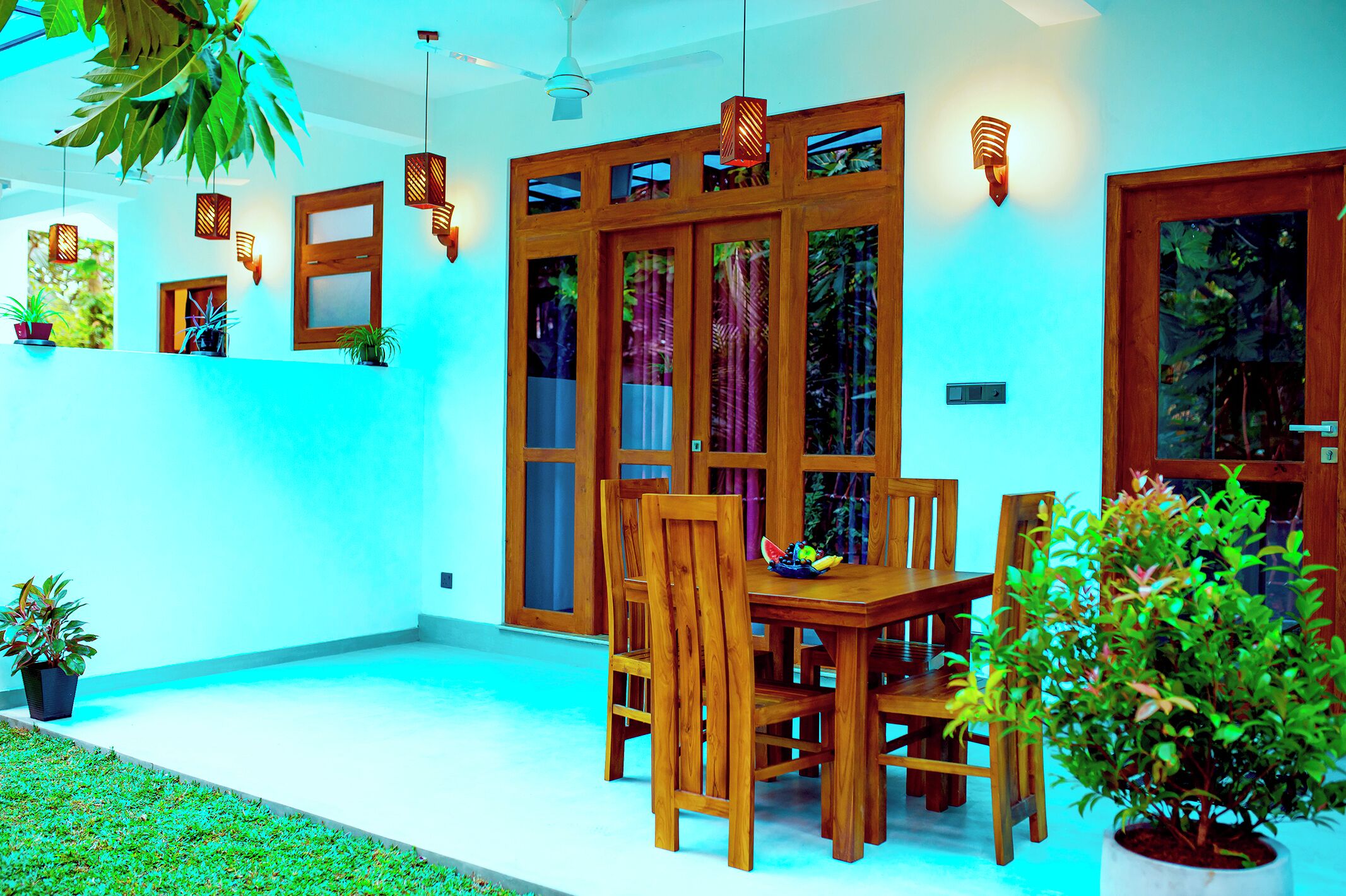 A dining area with wooden furniture and potted plants.