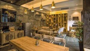 A modern kitchen with a wooden dining table, chairs, and pendant lights. - Feng Mian Su She Guesthouse (Fenghuang)
