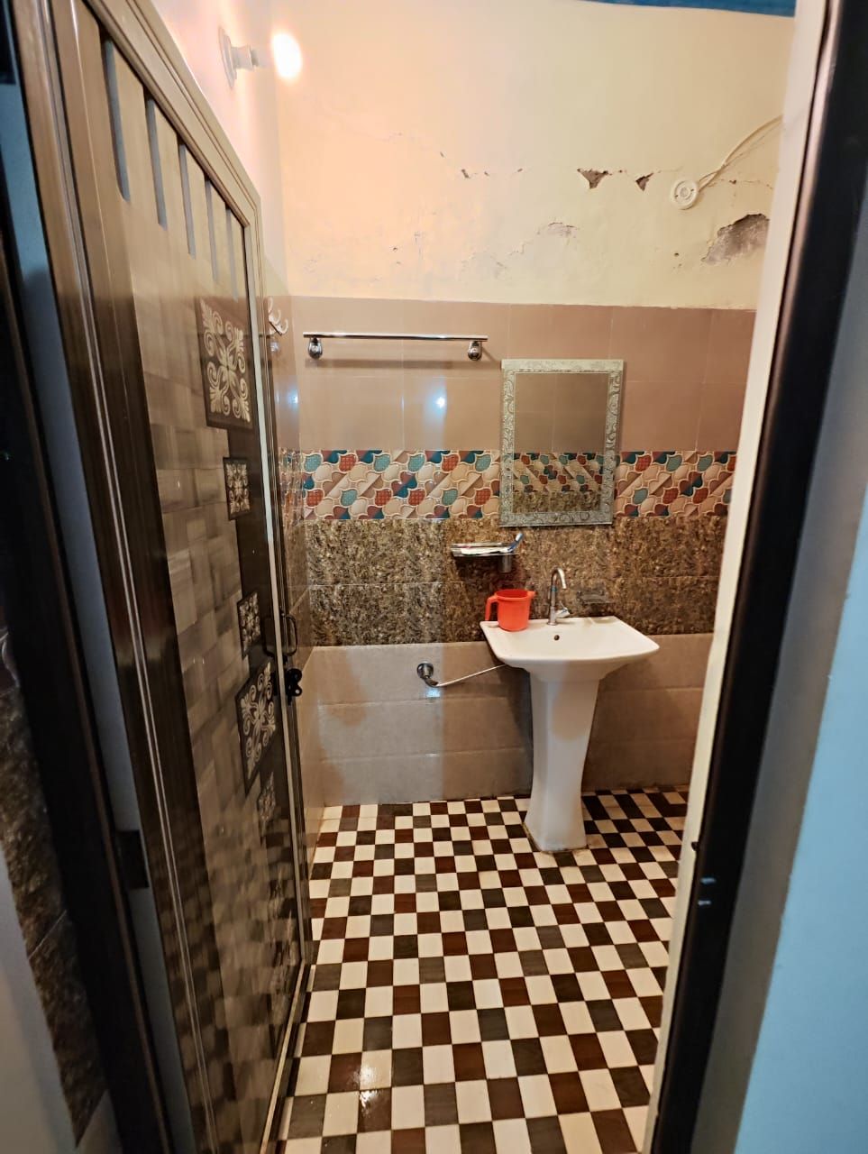 A bathroom with a checkered floor, a sink, and a shower.