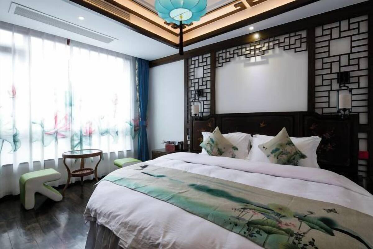 A bedroom with a bed, a small table, and a chair.