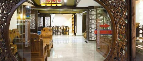 A traditional interior with wooden furniture and a glass partition.