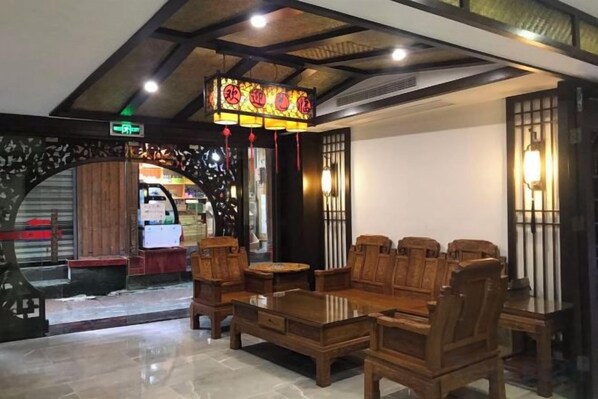 A traditional-style lobby with wooden furniture, a decorative ceiling, and a view of the outside. - Floral Hotel ·Fenghuang Grand Riverview (Fenghuang)
