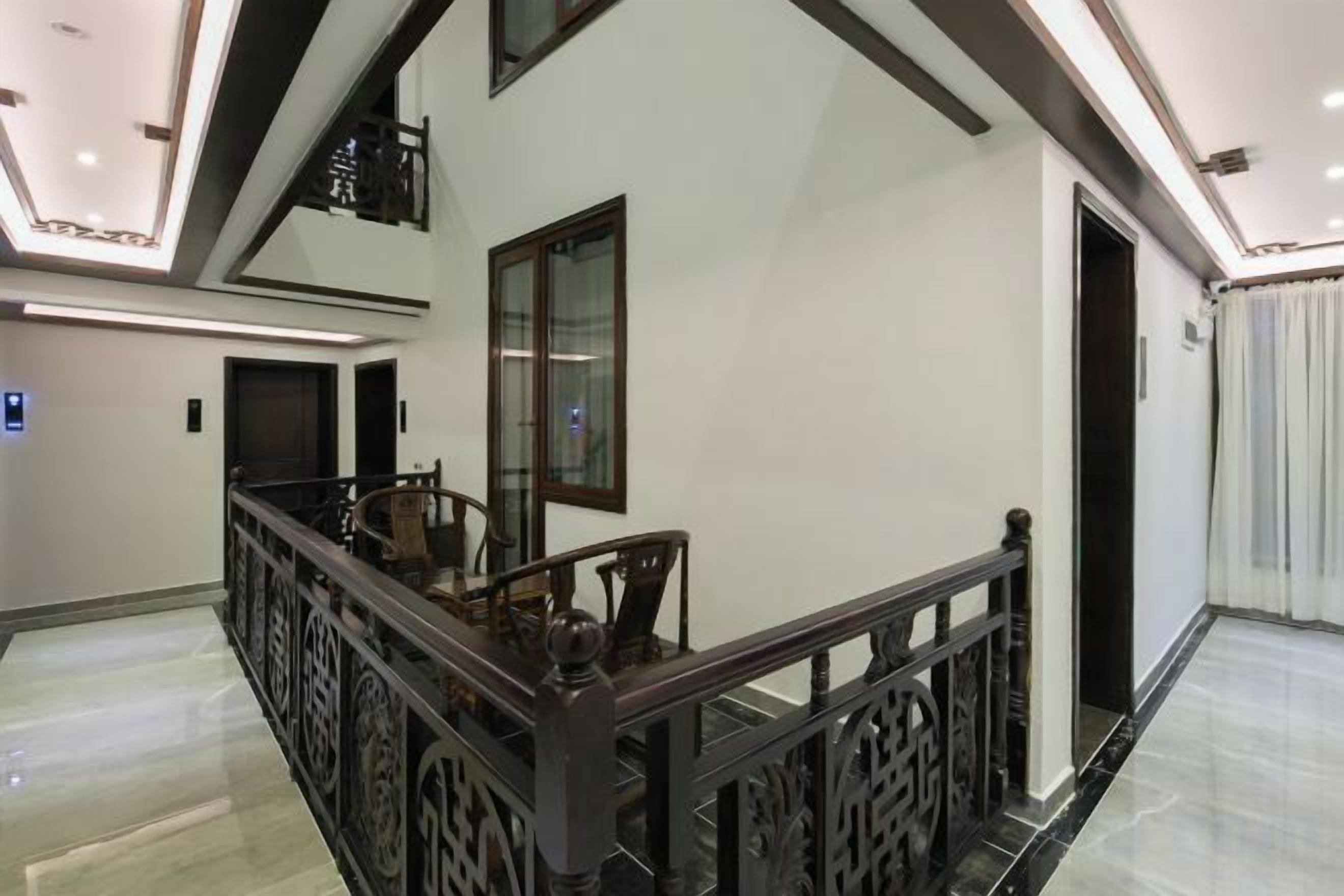 A modern interior with a staircase, a large mirror, and a door leading to another room.