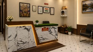 Un comptoir d’accueil au design en marbre, des certificats encadrés accrochés au mur, une enseigne indiquant « réception » et un tableau.