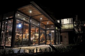A modern glass building with a wooden interior, a visible staircase, and a well-lit exterior at night. - Sun Valley Expert Building (Xinning)