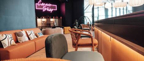 Een moderne lounge met een neonbord waarop 'Corner Shop' staat, rieten meubels en een houten bar.